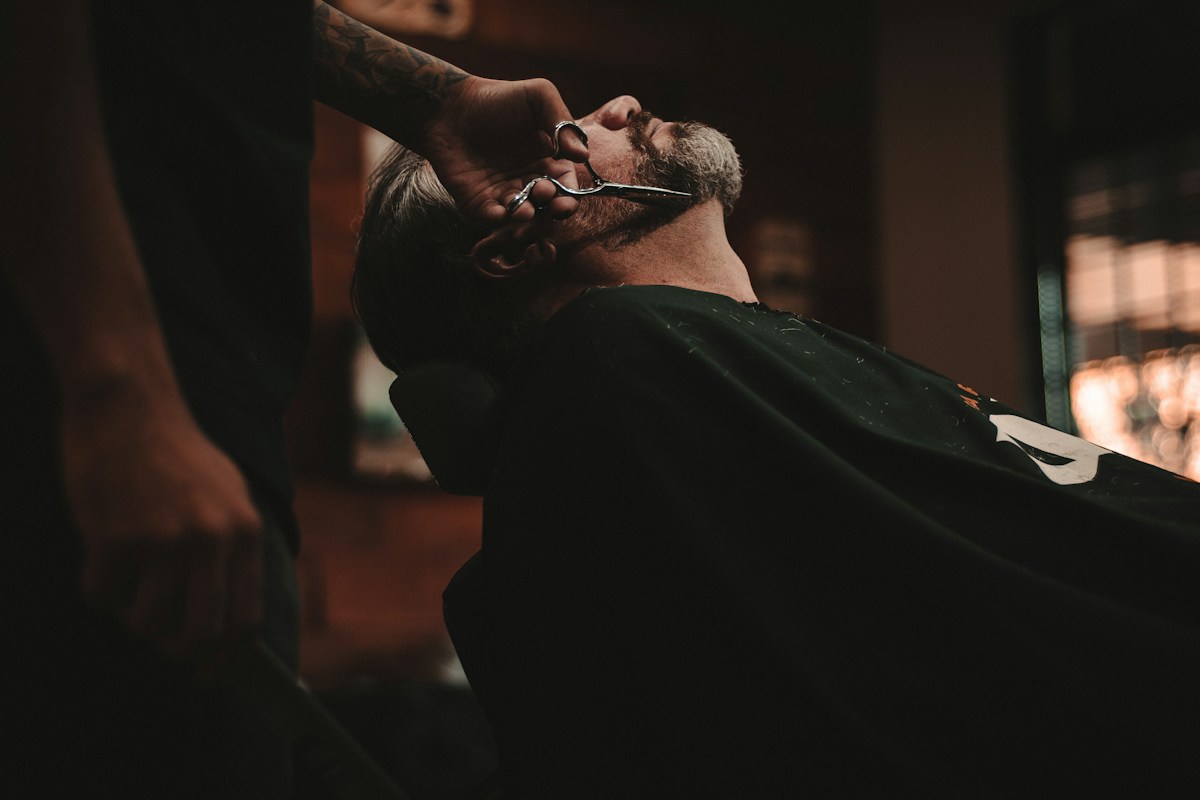 Ambiente sofisticado com cadeiras vintage e iluminação acolhedora da Barbearia The Shaving